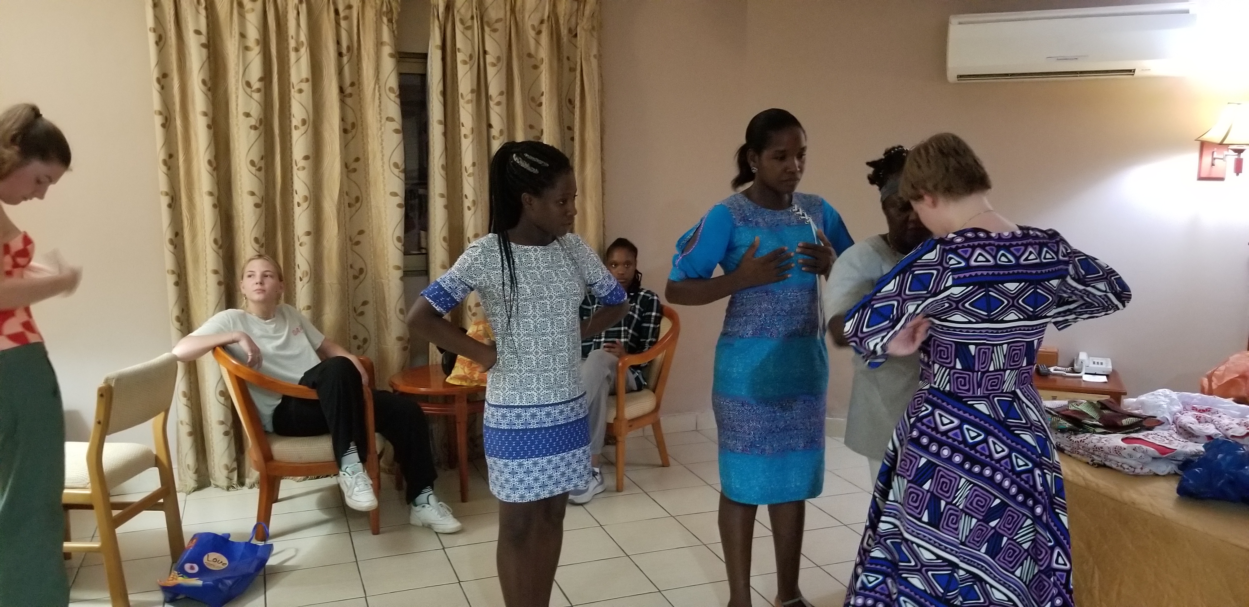 Students trying on handmade dresses in Accra hotel.